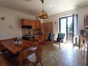 a kitchen and dining room with a wooden table and chairs at Casa Elisabetta in Ledro