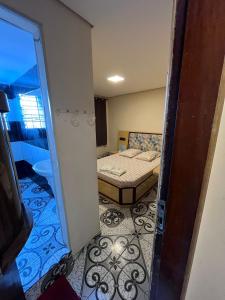 Habitación pequeña con cama y puerta a un dormitorio en Hotel Fragata en São Miguel Paulista