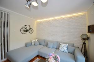a living room with a blue couch and a brick wall at The Nest - Urban Family place in Kotor
