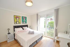 a white bedroom with a bed and a window at The Nest - Urban Family place in Kotor