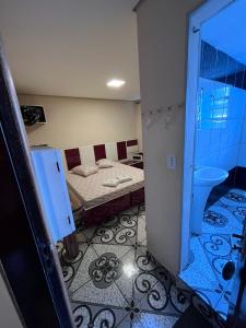 Habitación pequeña con cama y baño. en Hotel Fragata en São Miguel Paulista