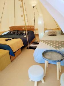 a bedroom with two beds and a table in a tent at Tiny House Village Resort 