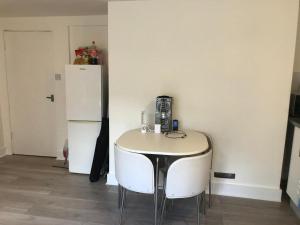 a kitchen with a table and two chairs and a refrigerator at 29a Margate in Kent