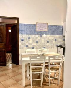 カステッランマーレ・デル・ゴルフォにあるA 'Du Passiの白いテーブルと椅子が備わるキッチン