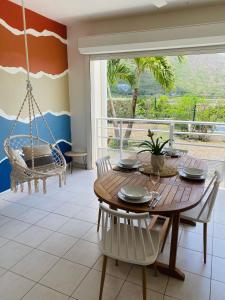 a dining room with a table and a swing at Appartement cosy à Grand Case, proche aéroport. in Grand Case