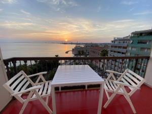 a table and chairs on a balcony with a view of the ocean at Aragona Luxury Apartment - Fronte Mare in Taranto