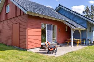 a red house with a patio and a table and chairs at Ostsee Landurlaub auf dem Ferienhof OFC 21 in Kröpelin