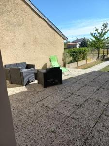 a patio with two chairs and a building at gite St anne in Fresnes-en-Woëvre