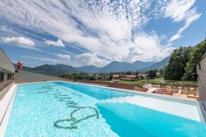 a swimming pool with a view of mountains at Hotel Bussi Baby in Bad Wiessee