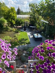 un jardin avec des fleurs violettes, une table et des bancs dans l'établissement Ferienwohnung Müller, à Stendal