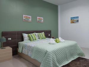 a bedroom with a bed with a green comforter at Villa loved beach AO NAM MAO 2 in Ao Nam Mao