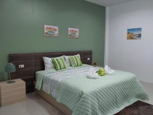 een slaapkamer met een bed met een groen dekbed bij Villa loved beach AO NAM MAO 2 in Ao Nam Mao
