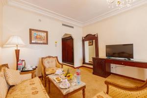 a living room with a couch a table and a tv at Grand Mogador Agdal & Spa in Marrakech