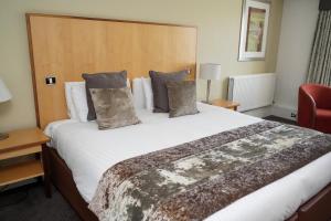 a large bed in a hotel room with a large bed at Hellaby Hall Hotel, BW Signature Collection in Hellaby