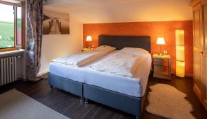 ein Schlafzimmer mit einem großen Bett und einem Fenster in der Unterkunft Berg Hotel Weingarten Garni in Rimsting