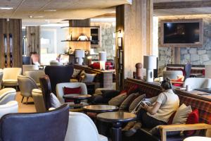 a woman sitting on a couch in a waiting room at Belambra Clubs Tignes - Val Claret in Tignes