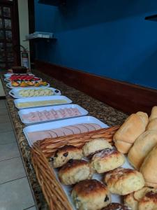 um buffet de produtos de pastelaria e pães numa mesa em Pousada Exuberante em Abraão