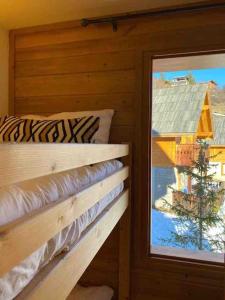 Una habitación con ventana y una cama en una cabaña en Appartement COSY à Praloup, 43m2, vue magnifique en Uvernet-Fours