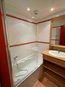 y baño con bañera y lavamanos. en Appartement COSY à Praloup, 43m2, vue magnifique en Uvernet-Fours