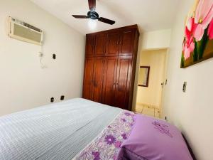 - une chambre avec un lit et une armoire en bois dans l'établissement Apartamento Meia Praia - Itapema, à Itapema