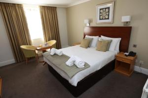 a hotel room with a bed with towels on it at Hellaby Hall Hotel; BW Signature Collection in Hellaby