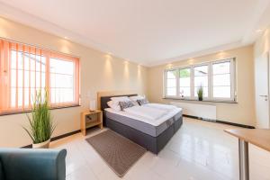 ein Schlafzimmer mit einem Bett in einem Zimmer mit Fenstern in der Unterkunft Pension Sonne Appartements in Minden