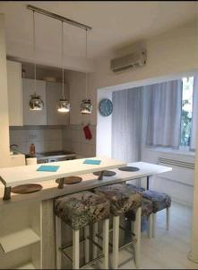 a kitchen with a table and two bar stools at Apartmani Šišava apt "HARMONY" Vlašić in Vlasic