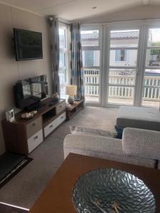 a living room with a couch and a tv at Tide Away Anderby Creek in Anderby