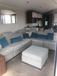 a living room with a large couch and blue pillows at Tide Away Anderby Creek in Anderby