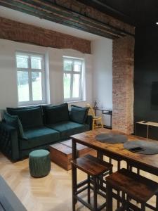 a living room with a green couch and a table at Apartament Gór-Ski Saneczkowa in Karpacz