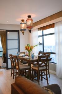 a dining room with a table and chairs and windows at Petronella Suites Apartment @ Jesselton Quay in Kota Kinabalu