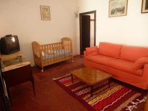 a living room with a couch and a baby crib at Appartamento Piagnaro in Pontremoli