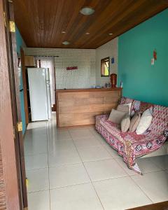 uma sala de estar com um sofá e um frigorífico em Chalé da Ana Aventureiro em Angra dos Reis