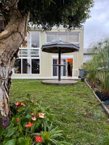 a house with an umbrella in the yard at Villa Niagara avec Spa in Sainte-Suzanne
