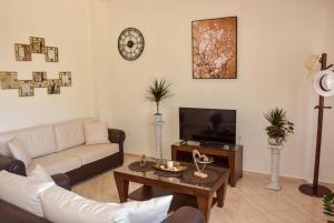 a living room with a couch and a tv at Sea View Villa Giorgios Five Bedroom in Gavalochori