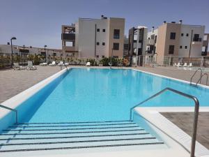 - une piscine d'eau bleue dans un bâtiment dans l'établissement Sol y Luz 2, à Caleta de Fuste