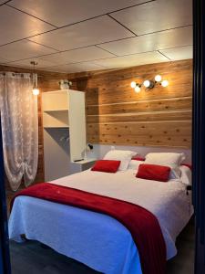 Sainte-Suzanne的住宿－Villa Niagara avec Spa，卧室配有带红色枕头的大型白色床