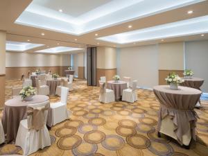 a banquet hall with tables and white chairs at The Paragon Hotel Mexico Santa Fe By Accor in Mexico City