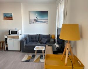een woonkamer met een bank en een tafel bij Appt FOURAS Centre Ville 50m de la Mer in Fouras