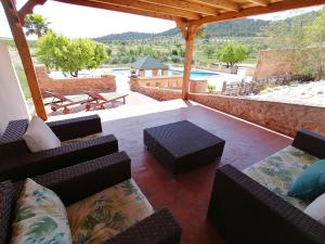 a patio with couches and a table and a pool at Finca Guillermo Murcia in Cañada del Trigo
