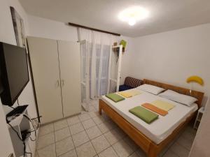 Un dormitorio con una cama y un televisor. en Apartments Iva i Marko, en Marina