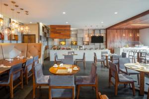 a restaurant with tables and chairs and a kitchen at The Paragon Hotel Mexico Santa Fe By Accor in Mexico City
