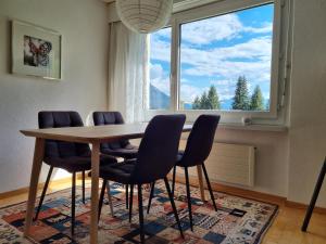 a dining room table with chairs and a large window at Valnaira (282 Dä) in Valbella