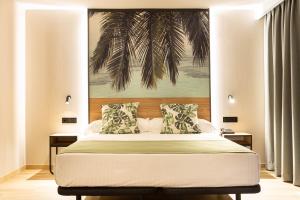 a bedroom with a bed with a palm tree above it at Hotel Primavera Park in Benidorm
