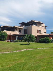 a large house with a green lawn in front of it at Appartamento a Punta Asfodeli in Porto Rotondo
