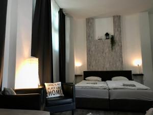a bedroom with two beds and a couch and a window at Benvenuto Apartman in Budapest