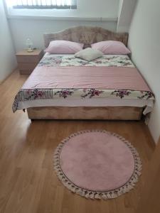 een bed in een slaapkamer met een tapijt op de vloer bij Pansion Brod in Slavonski Brod