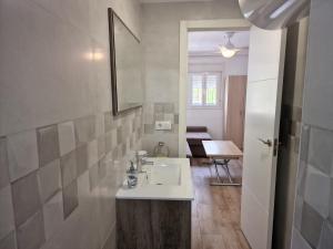 W łazience znajduje się umywalka, lustro i stół. w obiekcie Precioso apartamento centro Sevilla zona Nervión. w Sewilli