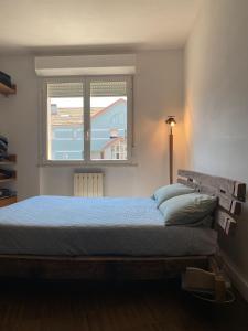 アルベンガにあるDelizioso Trilocale a due passi dal mare di Albengaのベッドルーム1室(青いベッドカバー、窓付)
