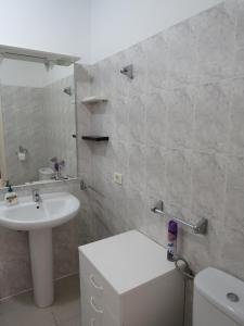 a white bathroom with a sink and a toilet at lidl Bright Central Two Bed Apartment PDC in Puerto del Carmen